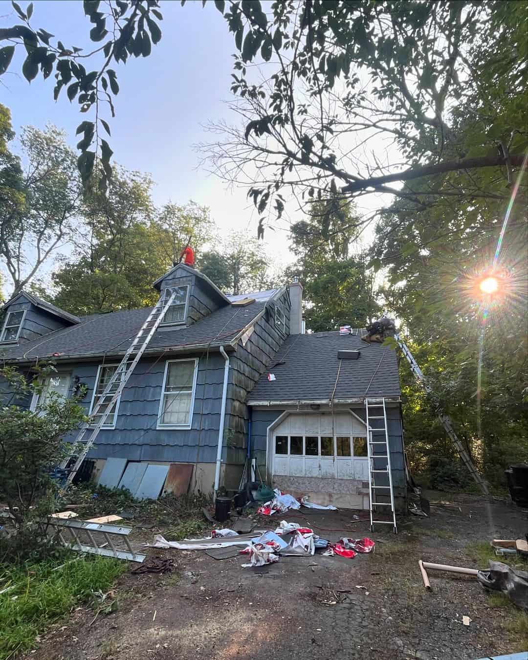 Roofing crew working on a home with a dormer and shingle roof