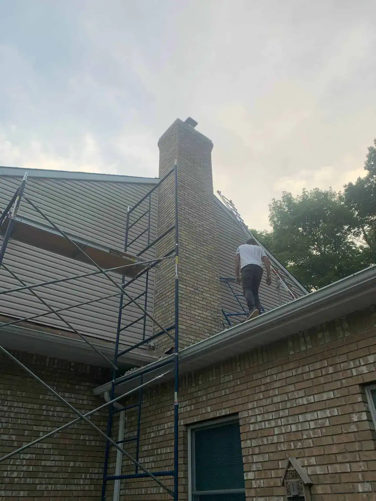 Boundless New Jersey Roofing Contractors performing roof repair on a brick house.