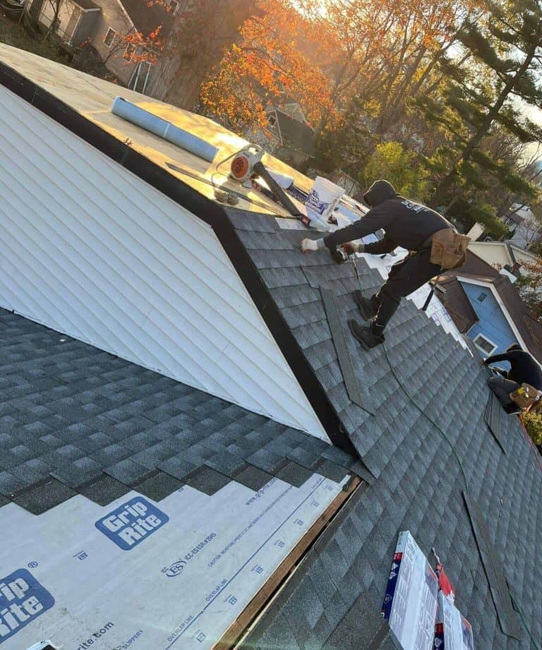Roofer installing shingles over new underlayment on a steep roof